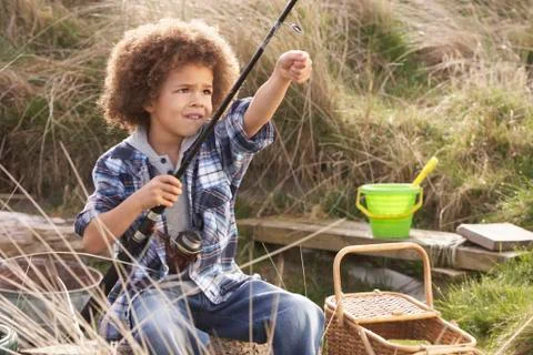 Young boy fishing at seaside Stock Photos