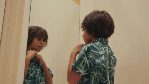 Young boy in fitting room trying on a new shirt Stock Footage 340924810