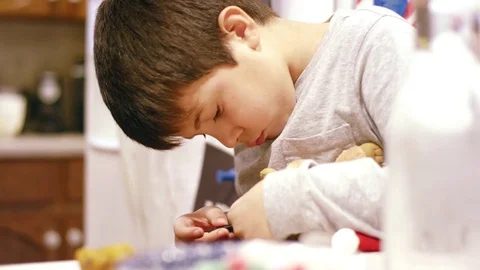 Young boy fixes his toy with screwdriver in the kitchen Stock Footage 71048100