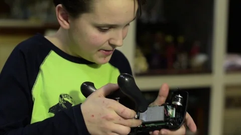Young boy fixing a game controller Stock Footage 102385861