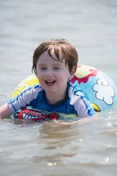 Young boy floating in inner tubes in a blissful state Stock Photos