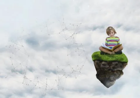 Young boy on floating rock platform  in sky reading book Stock Photos