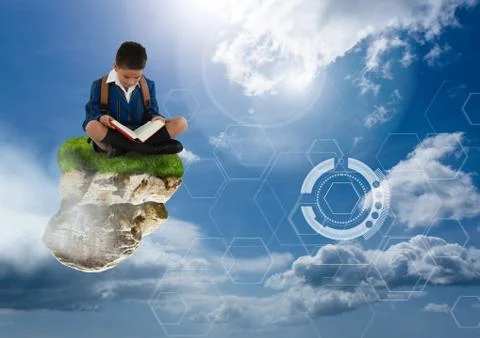 Young boy on floating rock platform  in sky reading book with futuristic 写真素材