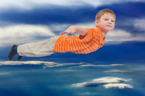 Young boy flying with cloud sky in background Stock Photos