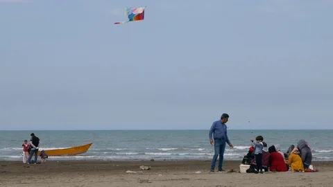 Young boy flying a rainbow kite on sandy beach of the Caspian sea Video stock 97035965
