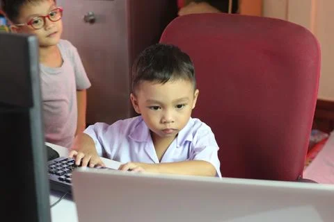 Young Boy Focused on Computer Screen in Classroom Setting Stock Photos