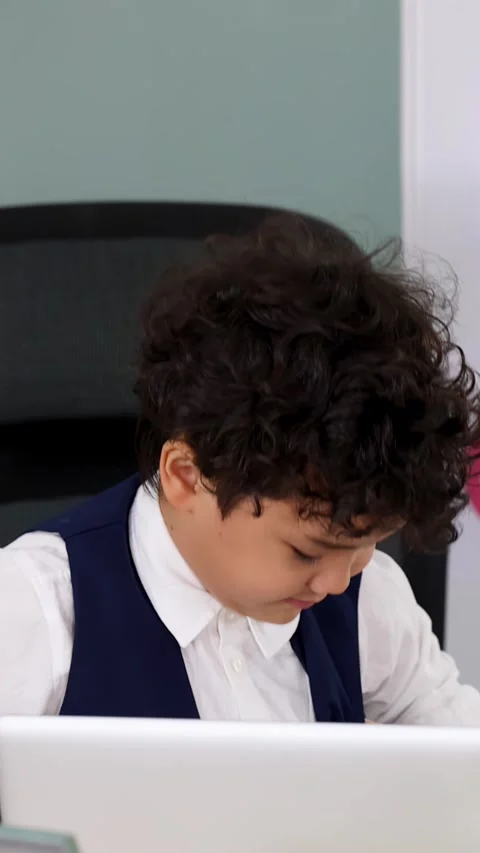Young Boy in Formal Vest Adjusting Clothes at Office Desk Stock Footage 338155561