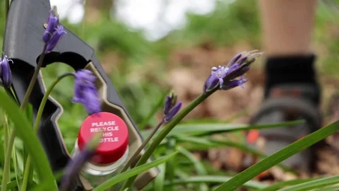 Young Boy Gently Picking Plastic Bottle From Wild Bluebell Flowers For Recycling Stock Footage 106870928