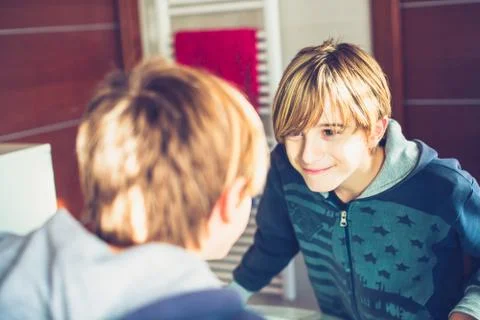 Young boy getting ready in the mirror before leaving home New day of ordinary Stock Photos