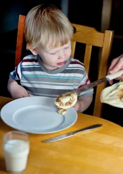 Young boy getting some more pancakes Stock Photos