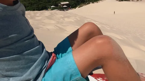 Young boy getting started slidding down sand dunes in South America Stock Footage 334482676