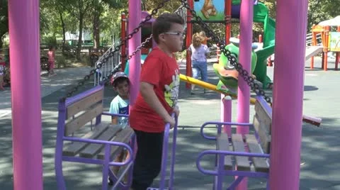 Young boy is given the swing in the park Vídeos de archivo 11888635