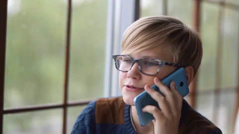 Young boy with glasses talking on the phone. Close-up. Stock Footage 161153301