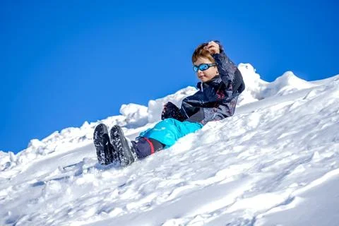 Young Boy Glides Down On The Snow Mountain. Stock Photos