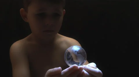 Young boy with a globe spinning and hovering over his open hands. Stock Footage 55357726