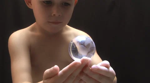 Young boy with a globe spinning and hovering over his open hands. Stock Footage 55357852