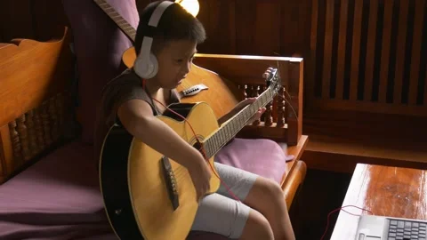 Young boy with a guitar plays the classical guitar 動画素材 141738278