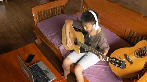Young boy with a guitar plays the classical guitar 動画素材 141738417