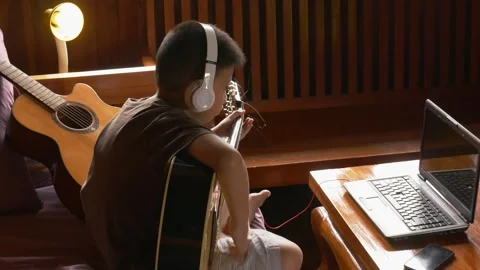 Young boy with a guitar plays the classical guitar 動画素材 141738432