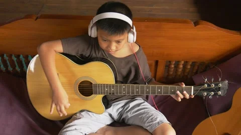 Young boy with a guitar plays the classical guitar 動画素材 141742087