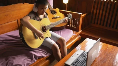 Young boy with a guitar plays the classical guitar. 動画素材 141742311