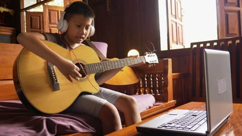 Young boy with a guitar plays the classical guitar. 動画素材 141857758
