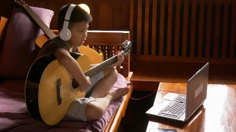 Young boy with a guitar plays the classical guitar. 動画素材 141857762