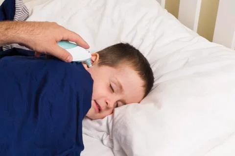A young boy has his temperature taken with a digitial thermometer Stock Photos