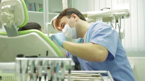 Young boy having a check up at dentist's surgery. Patient lying on exam chair Stock Footage 49046261