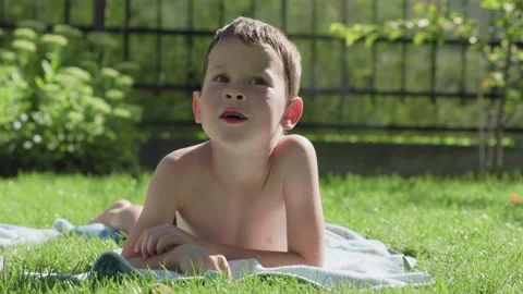 A Young Boy Having Fun and Enjoying a Beautiful Sunny Day While Laying on the Stock Footage 315860818