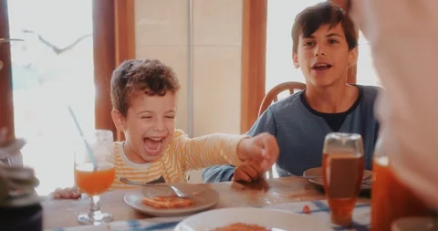 Young boy having fun eating healthy breakfast with family Stock Footage 92863299