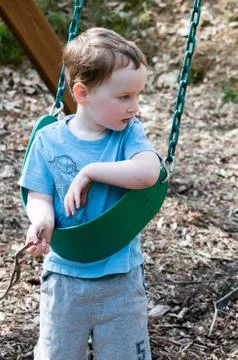 Young boy having fun on a swing Stock Photos