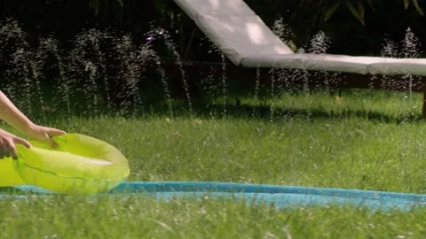 Young boy having fun on a waterslide in a green garden Video stock 78044799