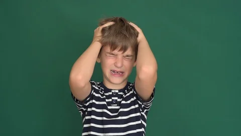 Young boy with headache holding his head on the green screen Stock Footage 118380838