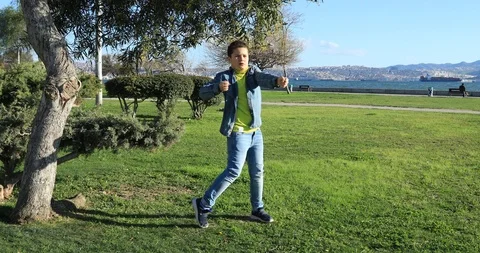 Young boy with headphone dancing on the lawn 3 Stock Footage 87692097