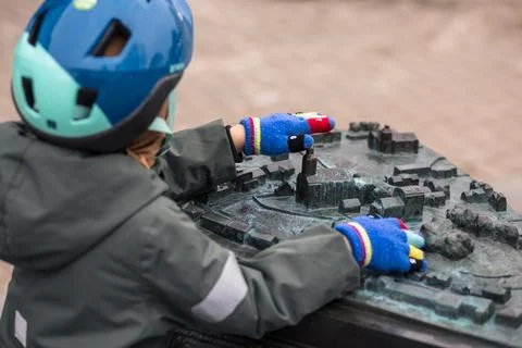 Young boy in helmet exploring a miniature city model Stock Photos