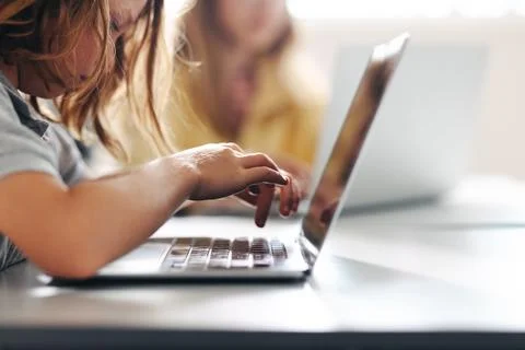Young boy hitting the keyboard in a classroom, completing a digital literac.. Stock Photos