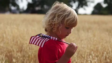 Young Boy Holding American Flag in Wheat Field on Farm for Fourth of July Vidéo 344194842