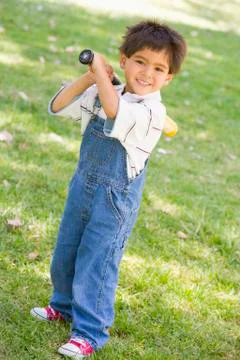 Young boy holding baseball bat outdoors smiling Stock Photos