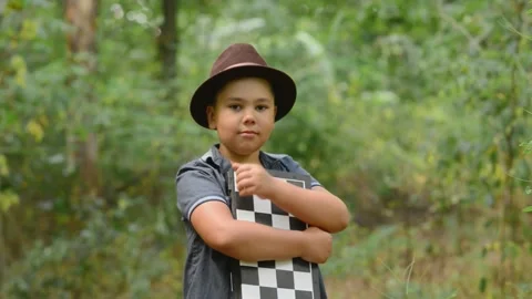 Young Boy Holding Chessboard and Showing Thumbs Up Outdoors Video stock 343550228