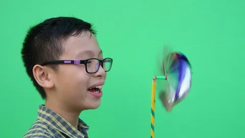 Young boy holding hand windmill  over green background Stock Footage 88934663