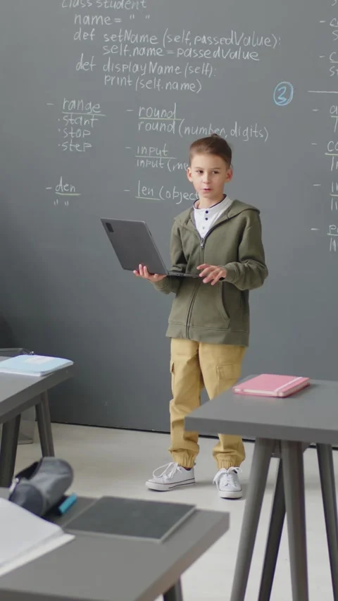 Young Boy Holding Laptop Making Report in Classroom 스톡 동영상 244695039