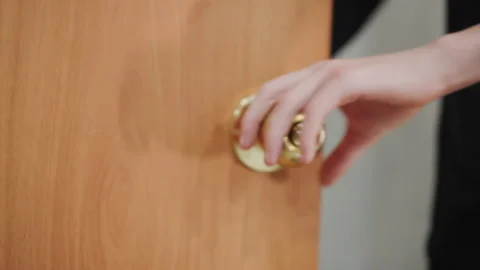 Young boy holding shiny knob. Teenager reaches for ornate brass door pull Stock Footage 332273984
