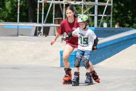 Young Boy Inline Skating With Instructor at Skate Park Stock Photos