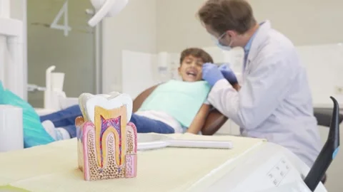 Young boy joyfully having his teeth examined by a dentist, focus on colorful Stock Footage 311522385