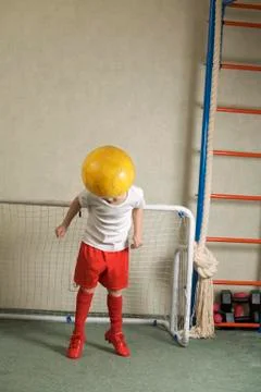 A young boy jumping to head butt a soccer ball away from a goal Stock Photos