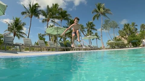 Young boy jumping into the pool, extreme slow motion, summer vacation vibes Stock Footage 337841595