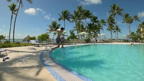 Young boy jumping to the pool, extreme slow motion, summer vacation vibes Stock Footage 337842092