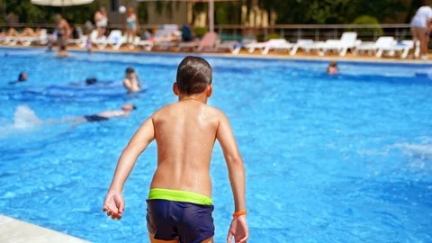 Young boy jumping in pool Vidéo 121112235