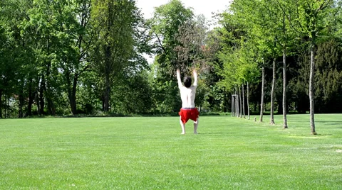 Young boy jumps back flip in the park Video stock 37599493